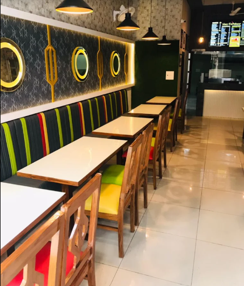 The Hey Foodies dining room with wooden chairs and illuminated wall panels